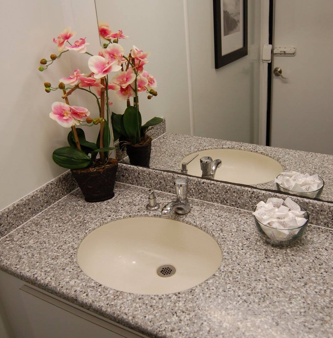 Luxury portable restroom with three urinals, framed mirrors, and floral decor inside.