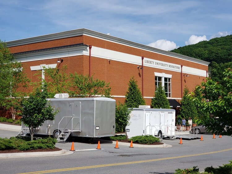 Luxury portable restrooms near a large event tent in Colorado.